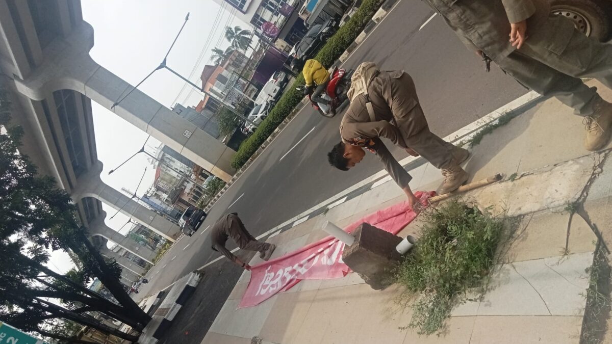 Gerak Cepat Satpol PP Tertibkan Umbul-Umbul diduga Berlabel Telkomsel di Trotoar Angkatan 45 Palembang